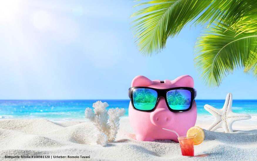 Rosa Sparschwein mit Sonnenbrille am Strand